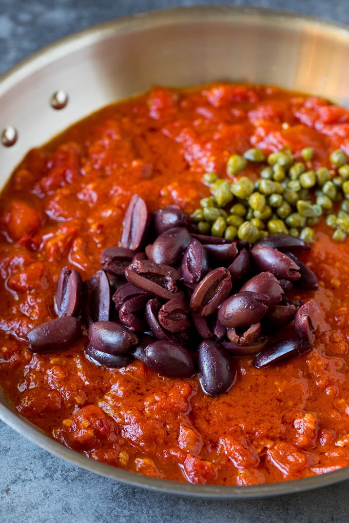 Pasta Puttanesca Recipe #pasta #tomatoes #olives #italianfood #dinner #jonep Tomato sauce with olives and capers on top.