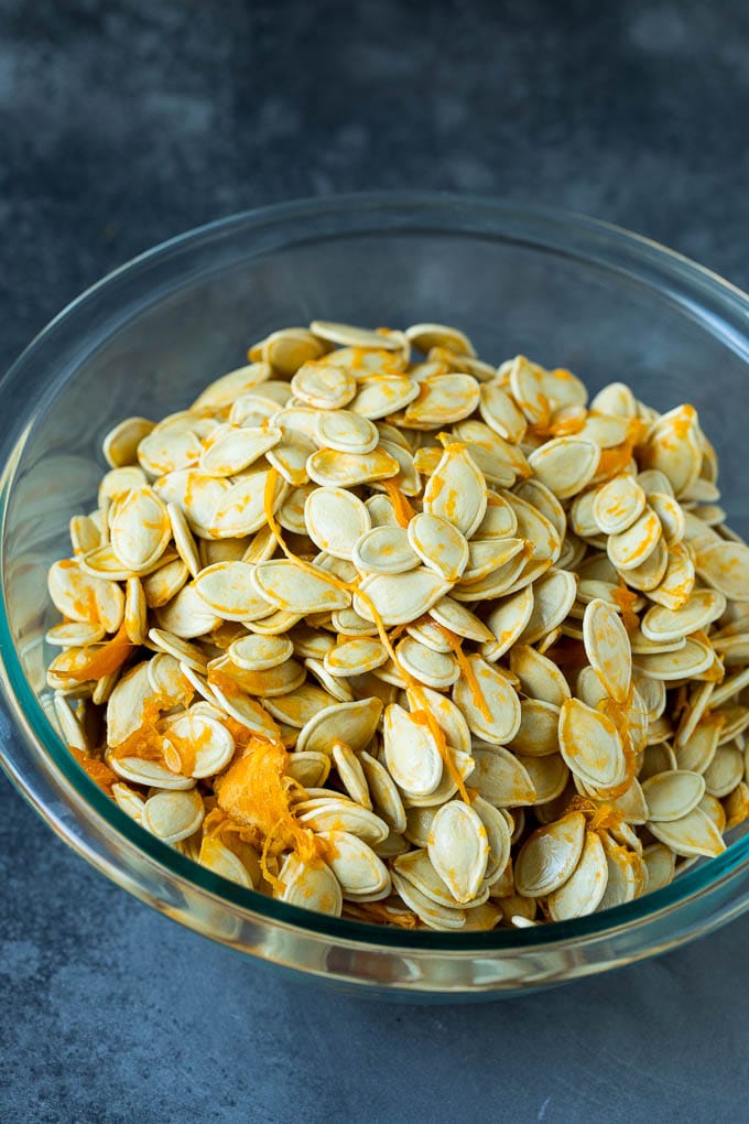 Pumpkin seeds and pumpkin flesh in a bowl.