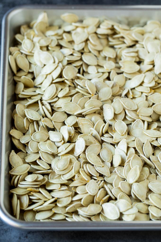 Seeds coated in seasonings and spread on a sheet pan.