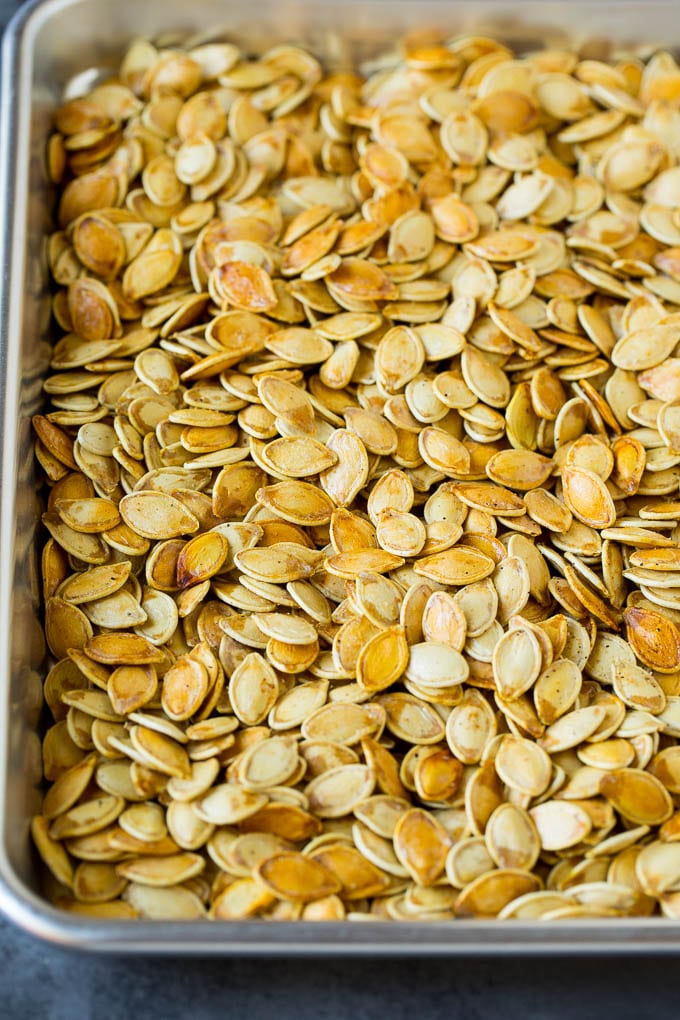 Roasted pumpkin seeds on a sheet pan.