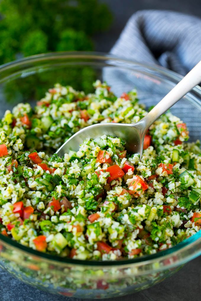 Tabbouleh Salad | Tabouli #salad #wheat #tomatoes #cucumber #healthy #sidedish #dinner #jonep A bowl of tabbouleh with a serving spoon in it.