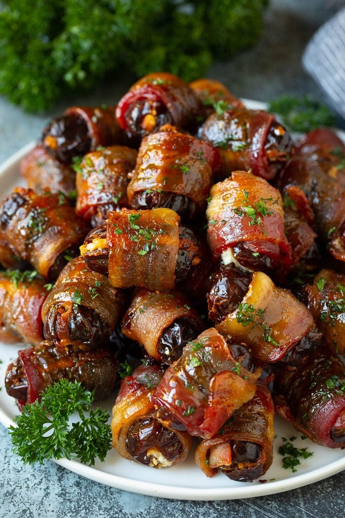 Bacon Wrapped Dates #appetizer #bacon #dates #cheese #jonep A plate of bacon wrapped dates stuffed with goat cheese.