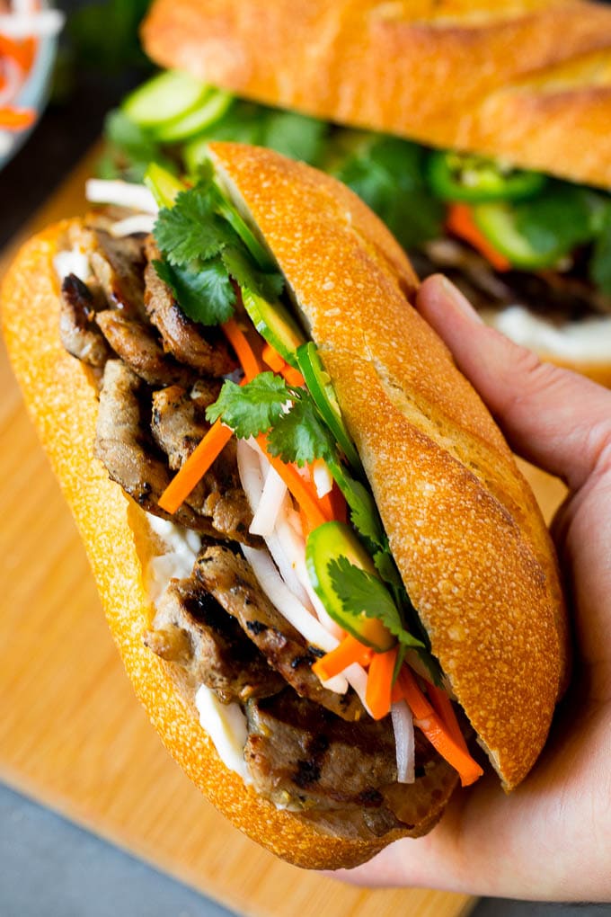 Bahn Mi Sandwich Recipe #sandwich #pork #lunch #dinner #jonep A hand holding a pork banh mi sandwich.