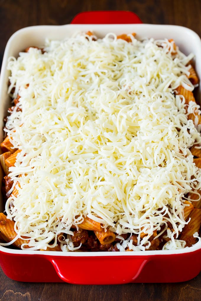 Baked Rigatoni Pasta #pasta #dinner #italianfood #groundbeef #jonep #casserole A pan of pasta in sauce topped with shredded cheese.