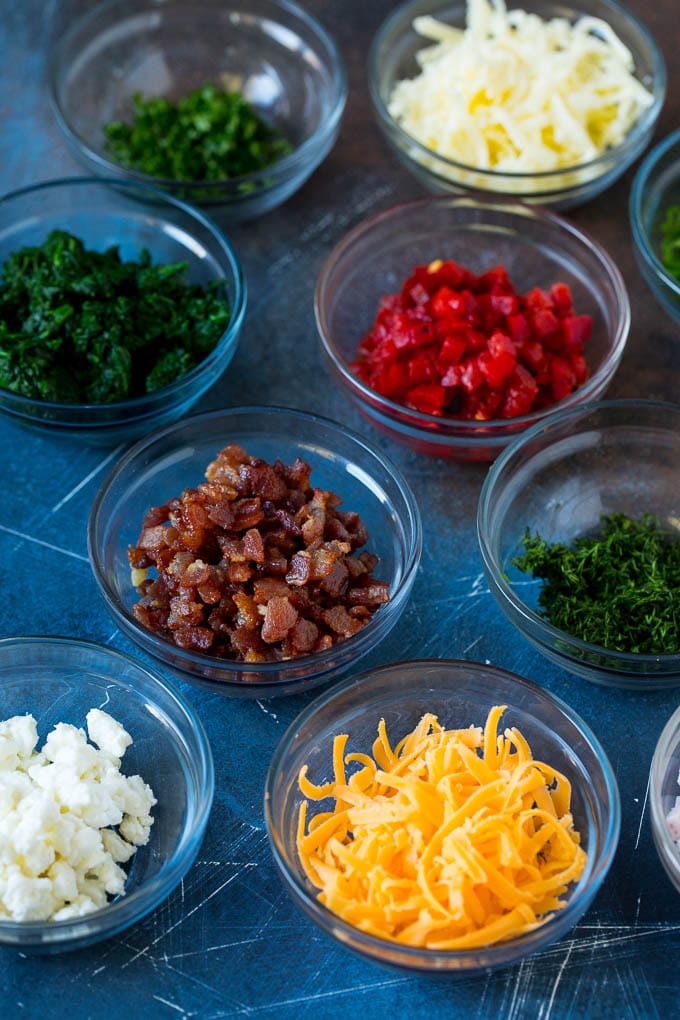 Mini Quiche Recipe #eggs #breakfast #brunch #appetizer #jonep Bowls of assorted flavorings for quiche.