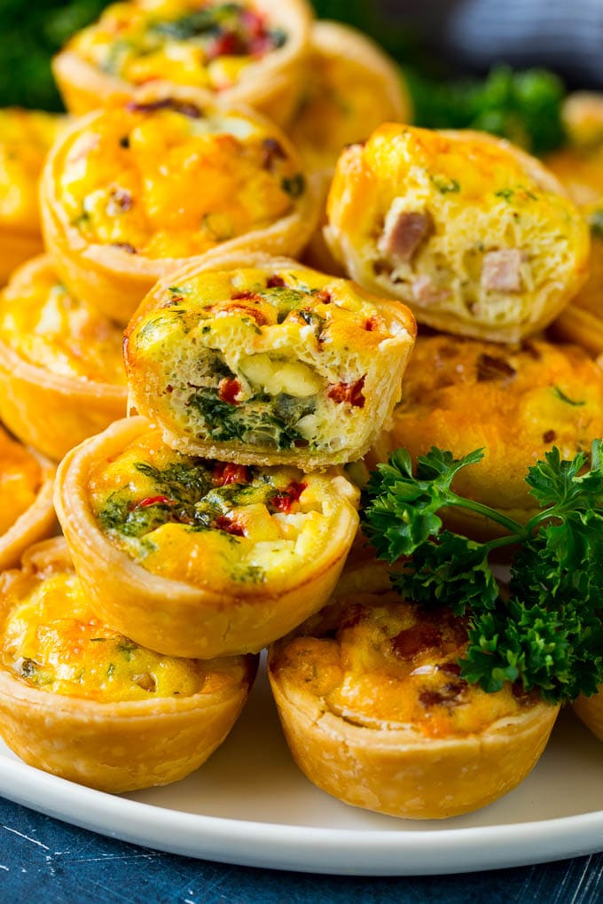 Mini Quiche Recipe #eggs #breakfast #brunch #appetizer #jonep A serving platter of mini quiche with some cut in half.