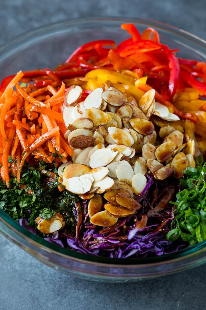 Asian Slaw Recipe #salad #slaw #sidedish #jonep Homemade dressing poured over Asian coleslaw.