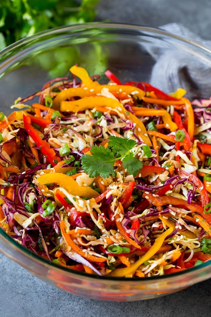 Asian Slaw Recipe #salad #slaw #sidedish #jonep A bowl of Asian slaw garnished with sesame seeds and herbs.