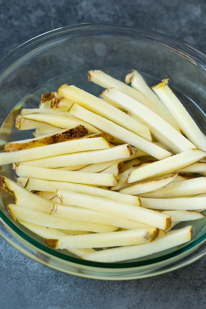 Homemade French Fries Recipe #potatoes #fries #dinner #jonep Sliced potato sticks in a bowl of water.