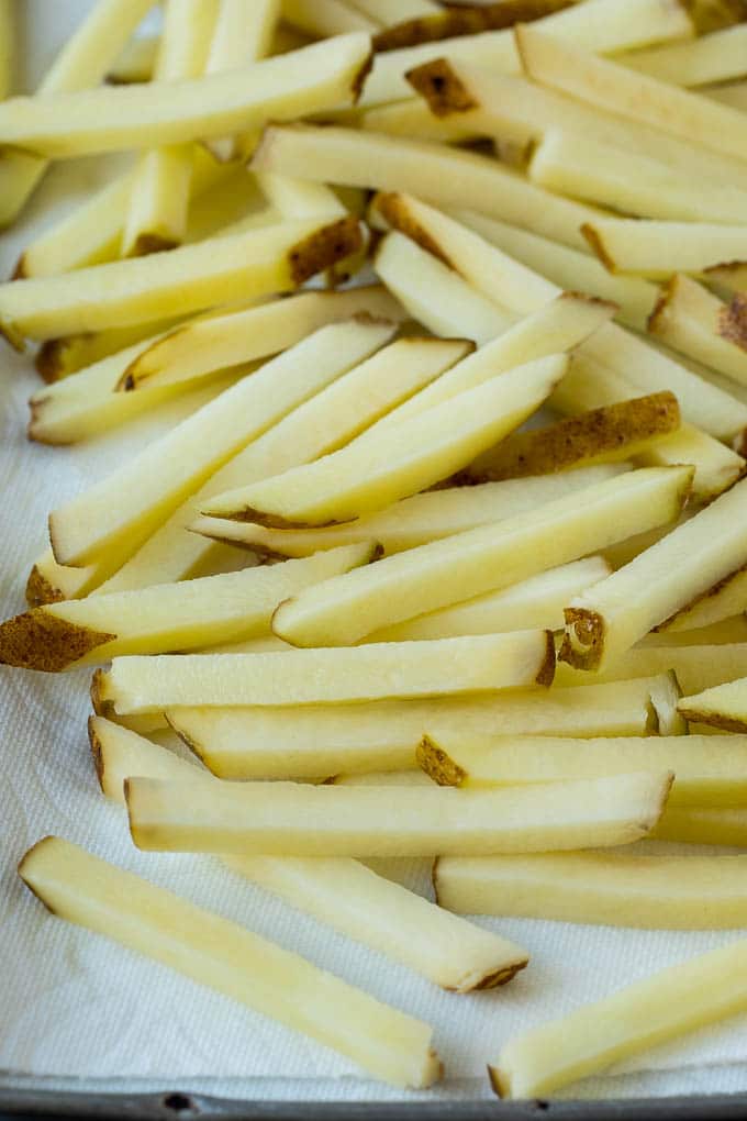 Homemade French Fries Recipe #potatoes #fries #dinner #jonep Potatoes cut into fry shapes on a paper towel lined pan.