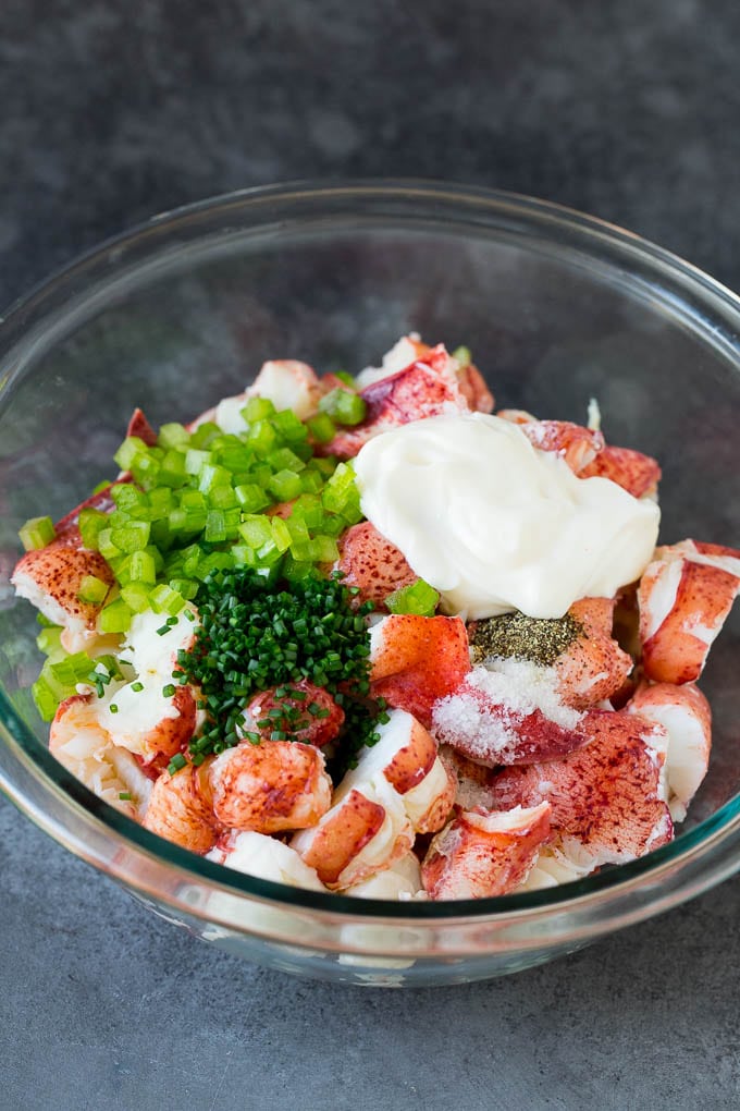 Lobster rolls stuffed with creamy lobster salad in a toasted bun. #lobster #jonep Lobster, chives, celery and mayonnaise in a bowl.