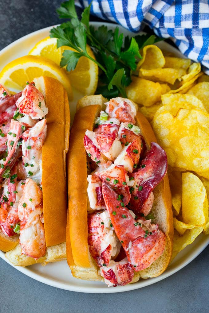 Lobster rolls stuffed with creamy lobster salad in a toasted bun. #lobster #jonep A lobster roll filled with a creamy seafood mixture and served with chips.