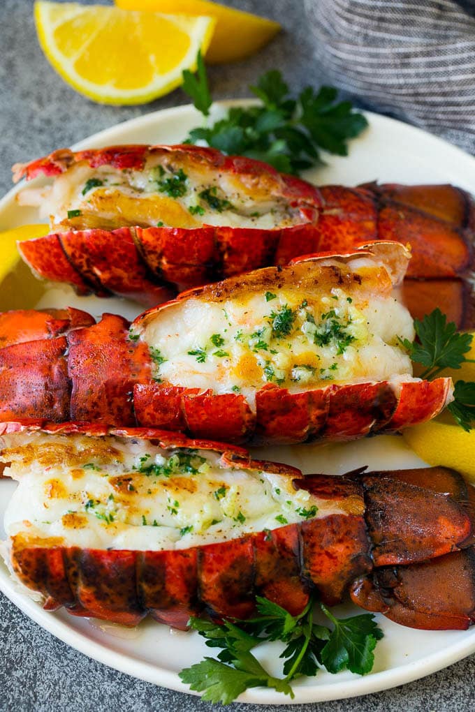 Grilled lobster tail drizzled with garlic butter is an easy and elegant dinner option. #lobster #jonep Grilled lobster tail topped with garlic butter and garnished with lemon and parsley.