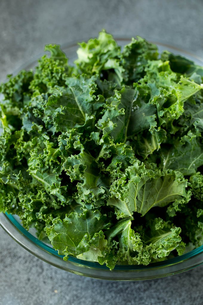 Sauteed kale flavored with olive oil and garlic, a quick and easy side dish! #kale #jonep Chopped kale in a mixing bowl.