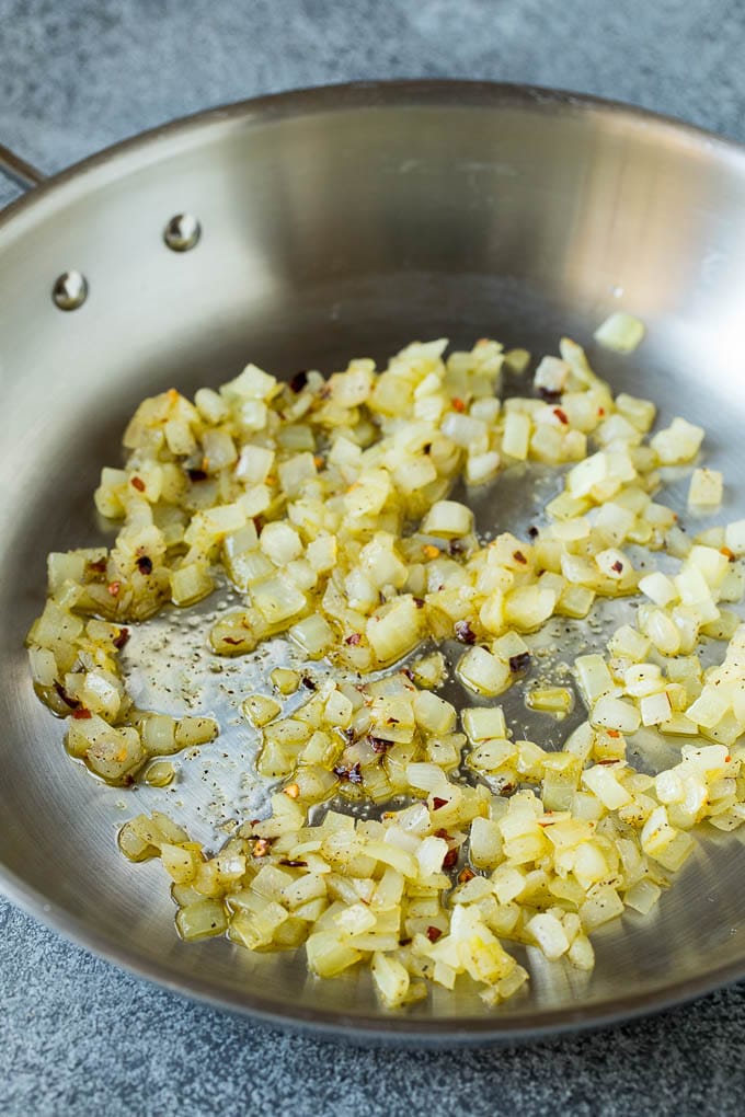 Sauteed kale flavored with olive oil and garlic, a quick and easy side dish! #kale #jonep Sauteed onions in a skillet.