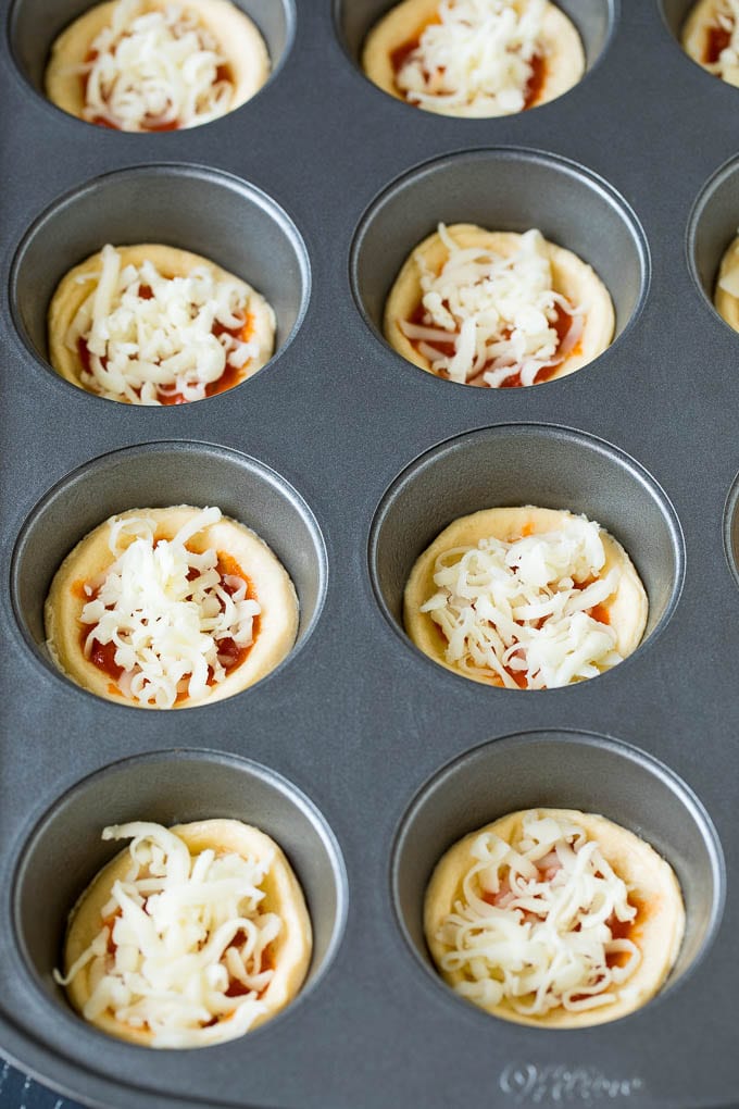 Mini pizzas topped with pepperoni are a fun and easy appetizer option. #pizza #jonep #appetizer Circles of dough topped with pizza sauce and shredded cheese.