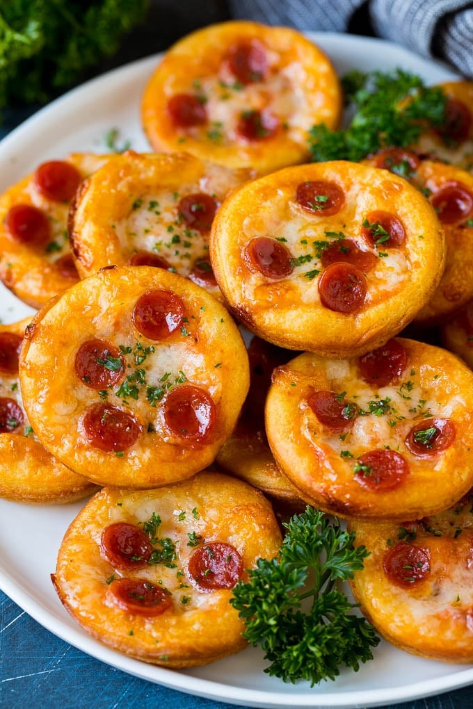 Mini pizzas topped with pepperoni are a fun and easy appetizer option. #pizza #jonep #appetizer Mini pizzas topped with melted cheese and pepperoni.
