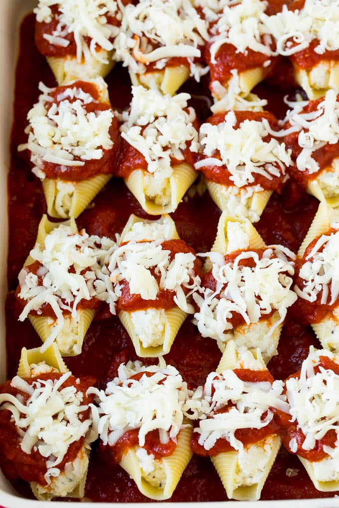 Baked stuffed shells filled with three types of cheese and topped with marinara sauce. #pasta #jonep Filled pasta topped with marinara sauce and shredded cheese.