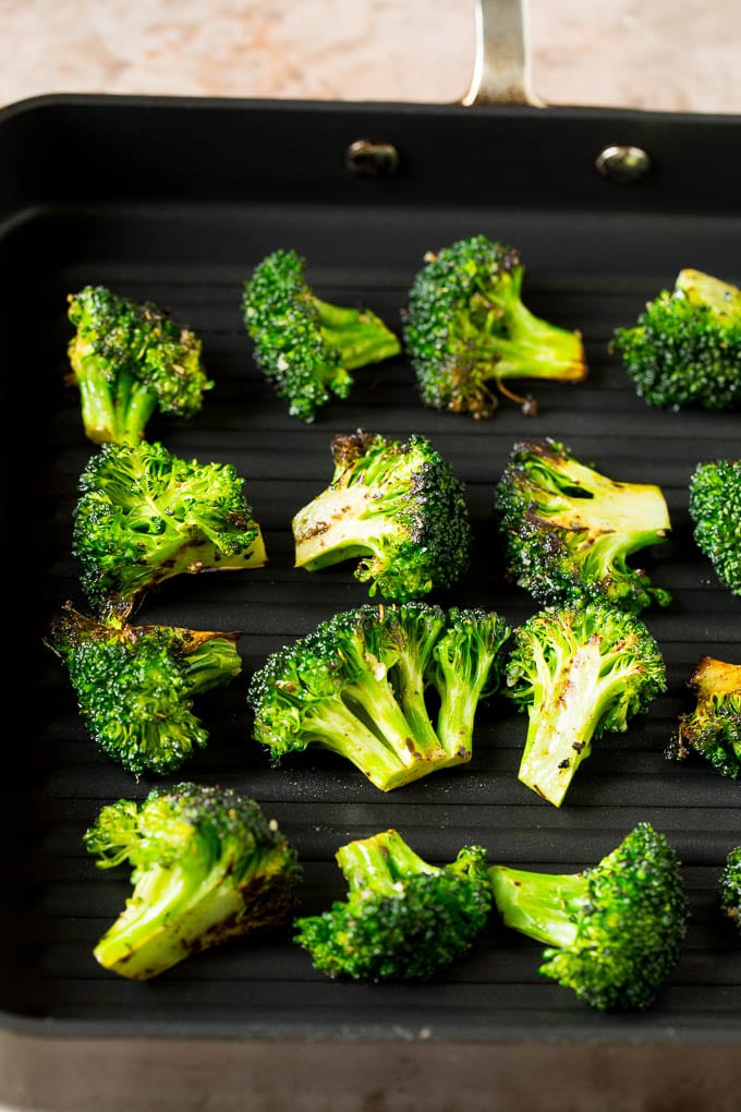Grilled broccoli is packed with flavor and is a colorful and healthy side dish! #broccoli #jonep Broccoli florets on a grill pan.