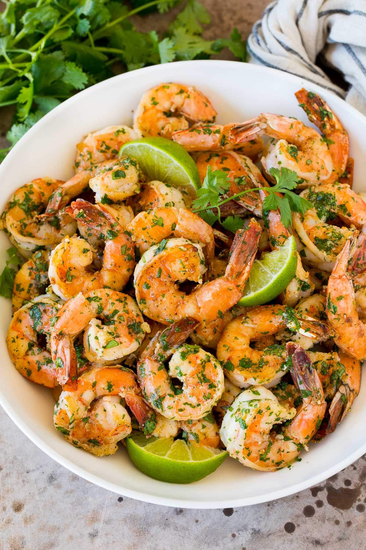 Cilantro Lime Shrimp | Seared Shrimp | Mango Salsa #salsa #shrimp #dinner #appetizer #jonep A serving bowl of cilantro lime shrimp with lime wedges in it.