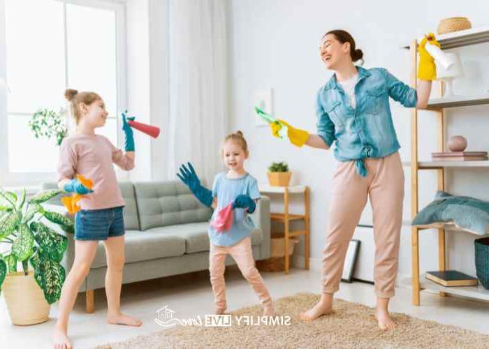 mom and daughters speed cleaning living room with music and timer