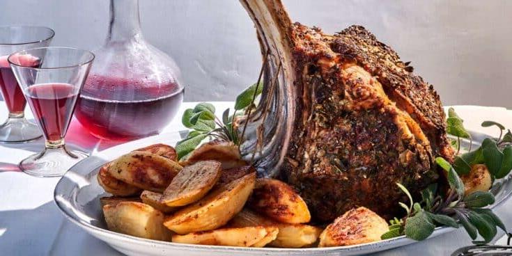Groot porsie Prime Rib gereed om bedien te word op 'n bord met bykosse.