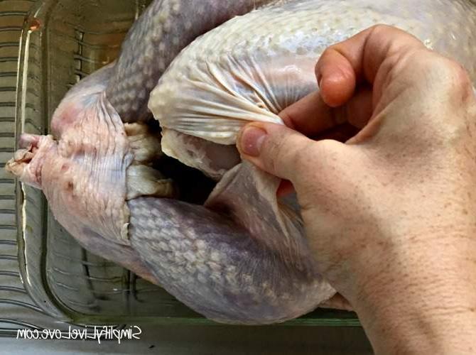 Αλάνθαστη Συνταγή Γαλοπούλας (Γιατί το Ψήσιμο της Γαλοπούλας σας Ανάποδα Αλλάζει τα Πάντα) 5 Γυναίκα που διαχωρίζει την πέτσα από τη γαλοπούλα για να τρίψει το μισό βούτυρο κάτω από την πέτσα.