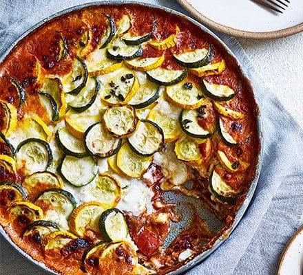 Gebakte ratatouille met 'n bolaag van bokmelkkaas.
