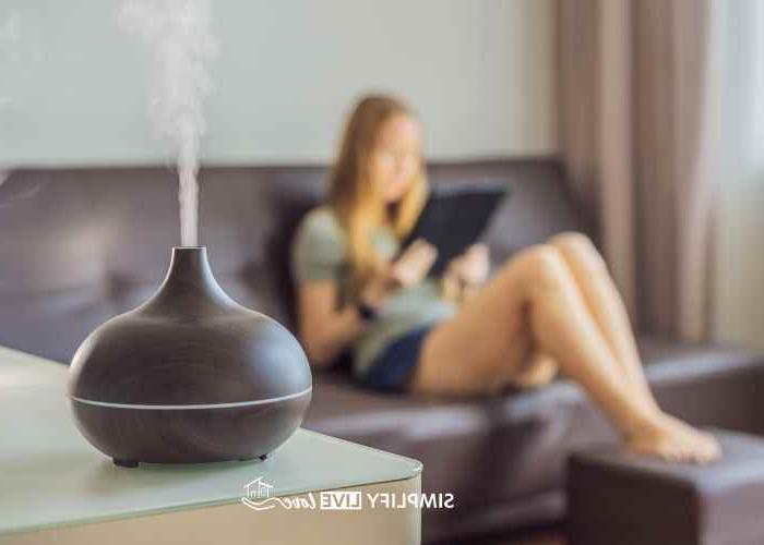 girl reading on couch with oil diffuser in foreground