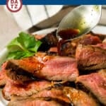 Flank steak marinade being spooned over slices of grilled flank steak.