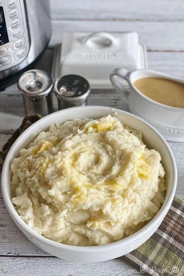 Τέλειος Instant Pot Πουρές Πατάτας (+ Συμβουλές Κατάψυξης & Αναθέρμανσης) 3 Κρεμώδης πουρές πατάτας με βούτυρο σε λευκό μπολ και μπολ με σάλτσα, αλάτι και πιπέρι στο βάθος