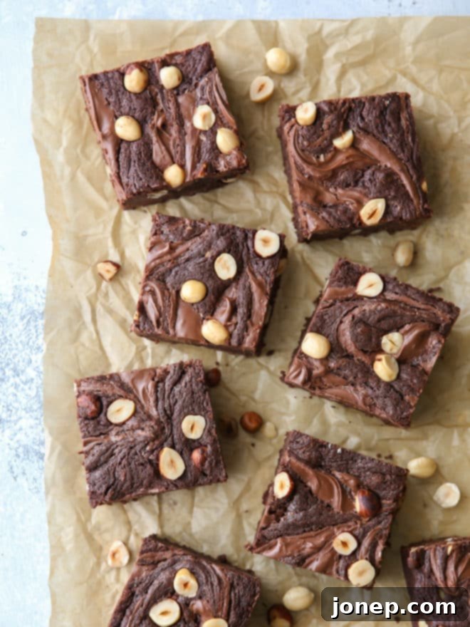 Nutella brownies with hazelnuts, close-up of a square brownie with a visible Nutella swirl and hazelnut pieces