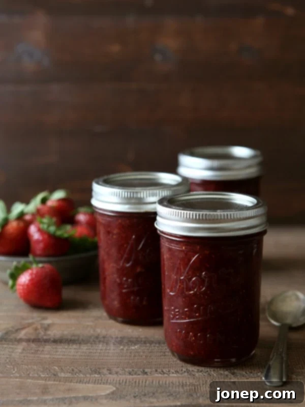 Delicious homemade pectin-free strawberry jam in a glass jar, ready to be enjoyed or preserved.