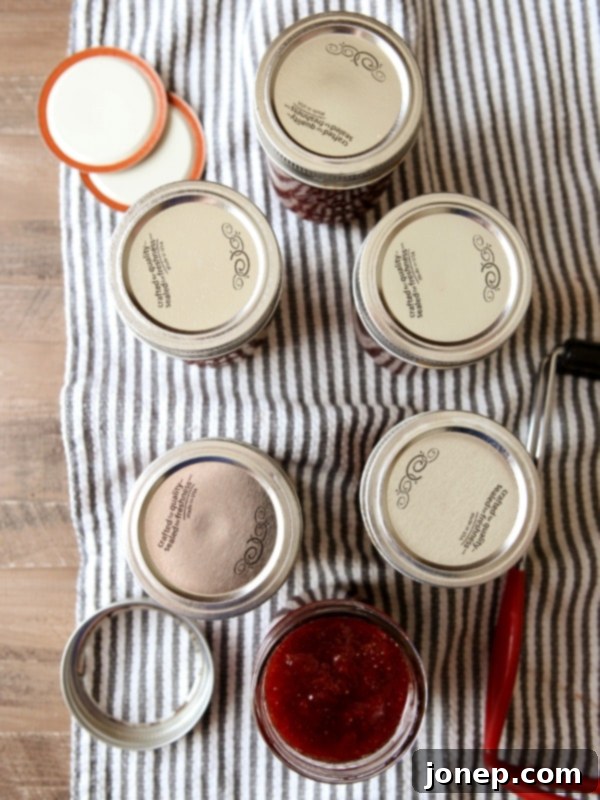 Assortment of homemade strawberry jam jars, showcasing different storage options.