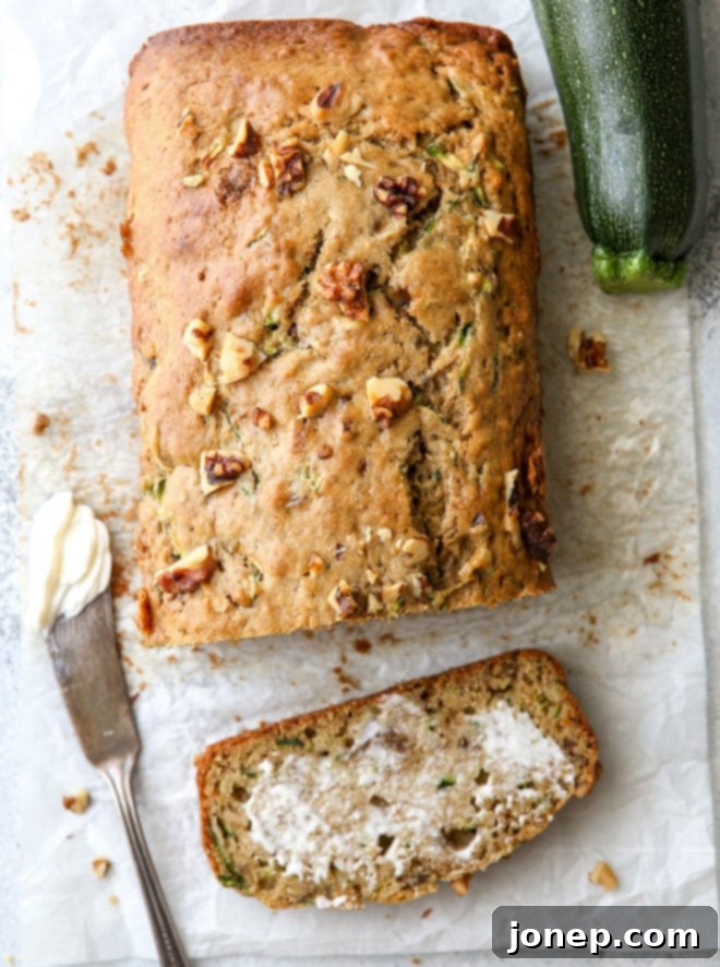 A close-up shot of a slice of moist banana zucchini walnut bread.