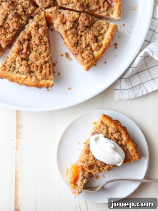 A beautifully golden-brown peach crumb tart cooling on a wire rack, ready to be sliced.
