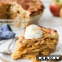 slice of mile high apple pie with ice cream on a plate