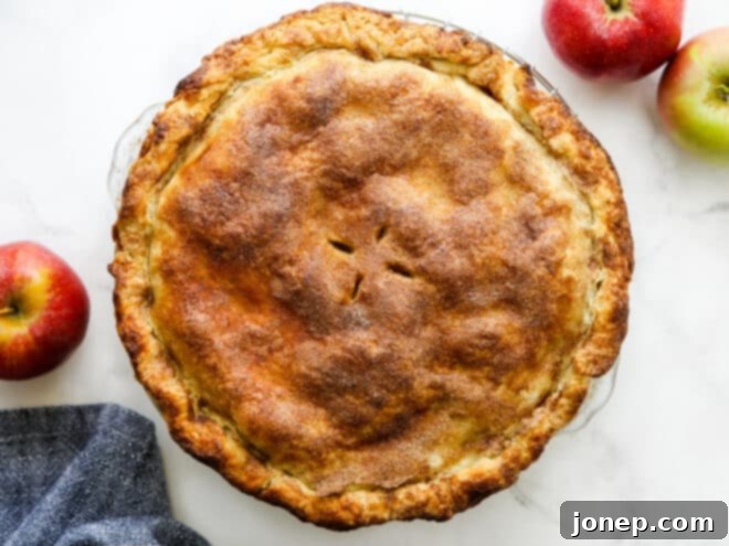 A freshly baked mile-high apple pie, golden brown and glistening.