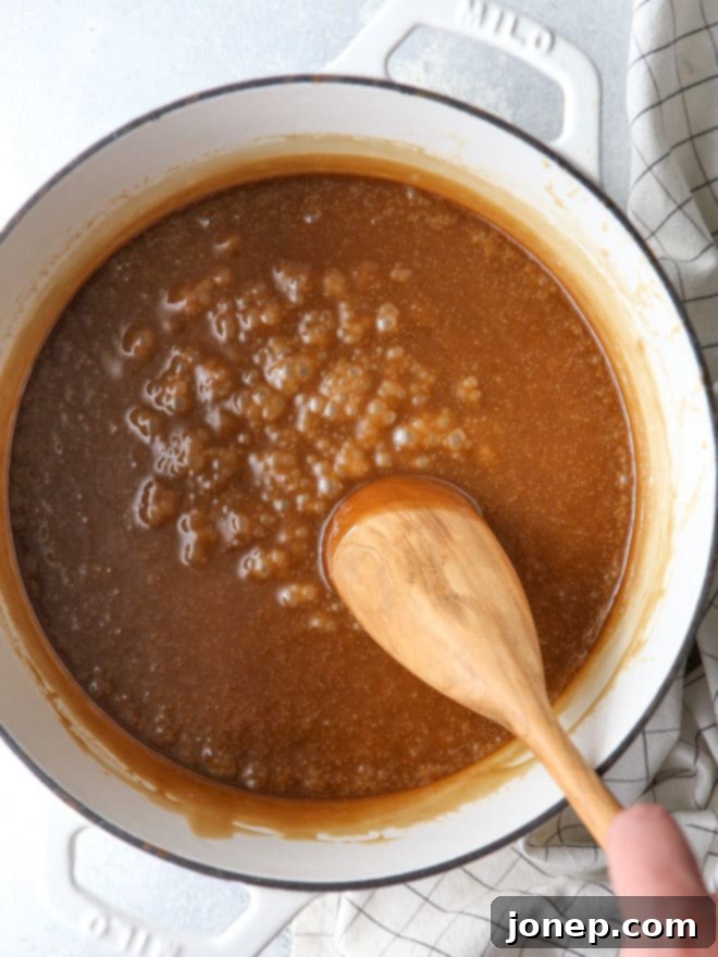 Rich and buttery caramel sauce bubbling in a pot, ready to coat the popcorn for a soft and chewy treat.