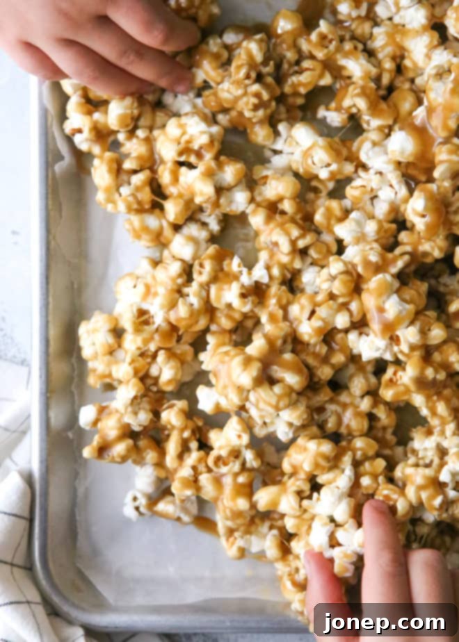 A generous serving of gooey, soft caramel popcorn in a bowl, ready to be enjoyed as a sweet treat.