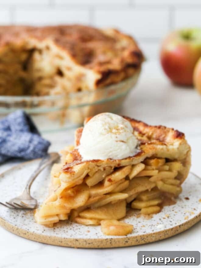 slice of mile high apple pie with ice cream on a plate