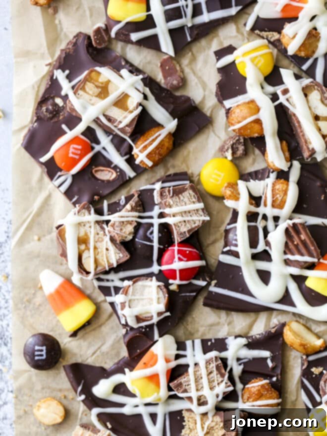 Halloween Candy Bark 6 Various pieces of Halloween candy bark, showcasing the mixed toppings and white chocolate drizzle