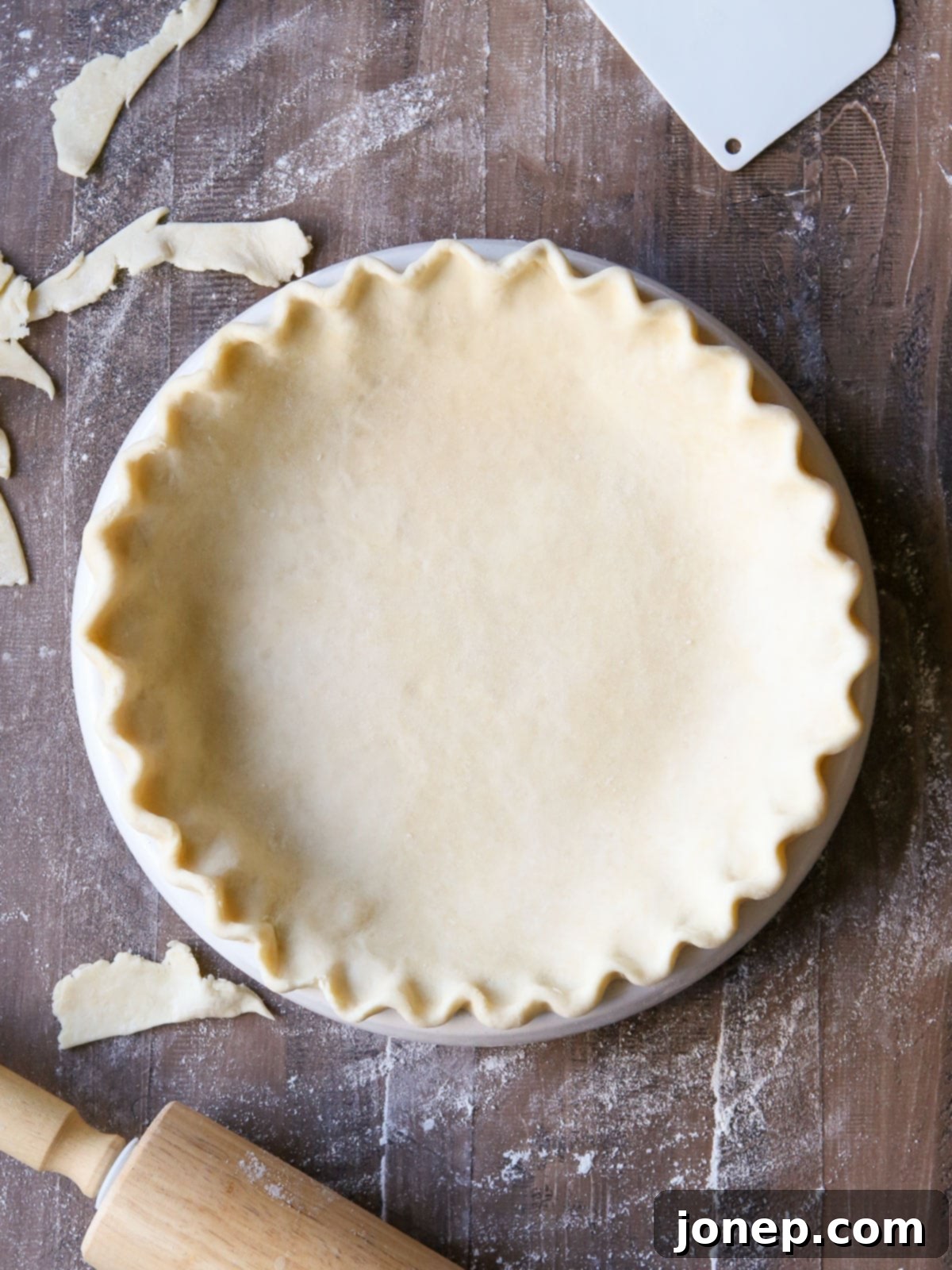 crimped pie crust in pie pan with rolling pin
