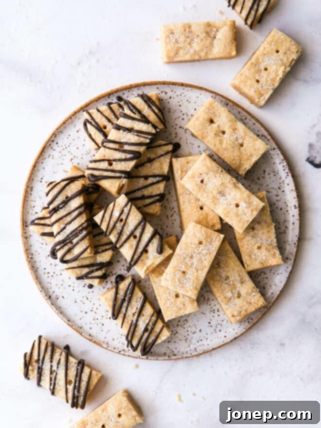 Nutty Brown Butter Shortbread 2 Overhead view of perfectly golden brown butter shortbread cookies arranged on a white plate, highlighting their rich color and inviting texture.