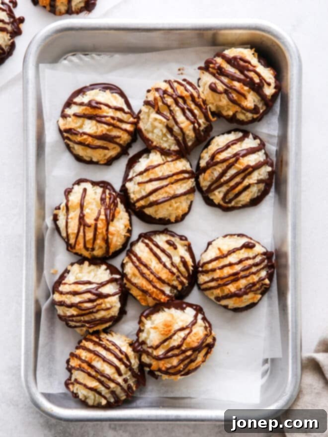 coconut macaroons drizzled with chocolate on a sheet pan