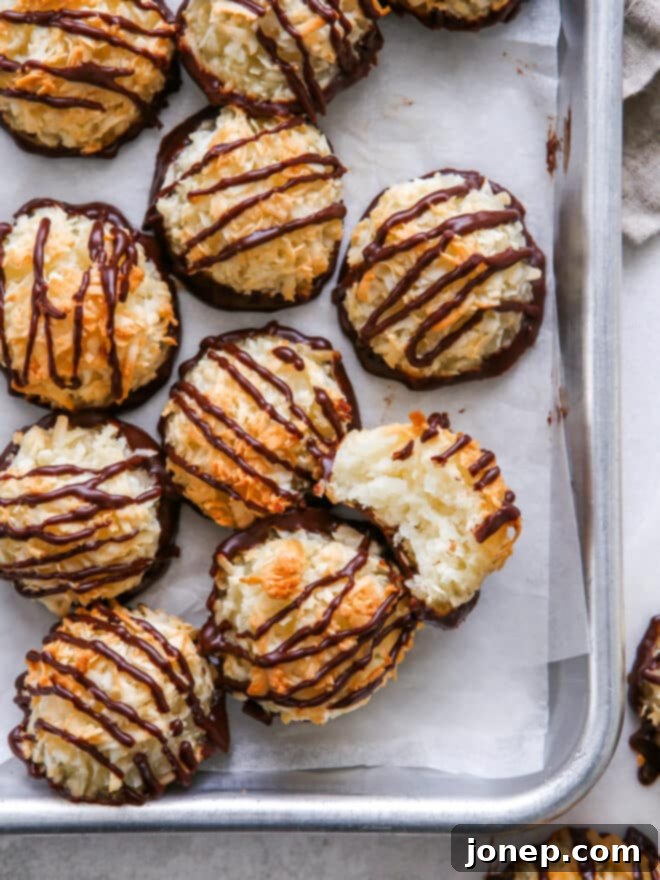 closeup of coconut macaroons, one with a bite taken out to see insides