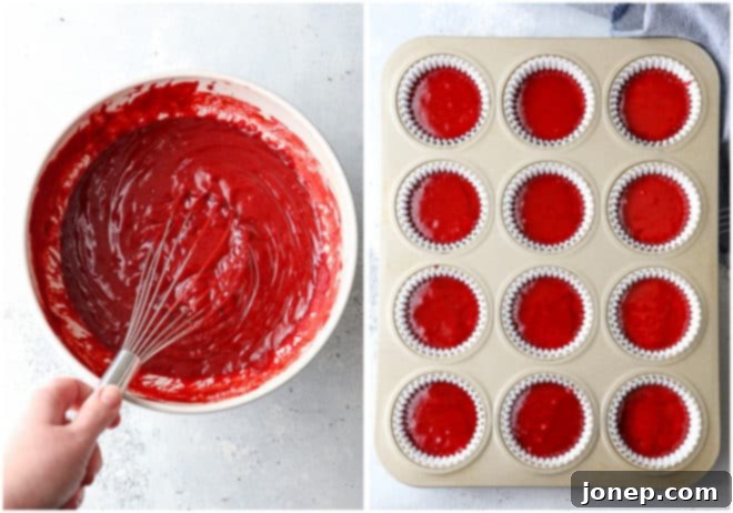 Red velvet cupcake batter neatly portioned into liners, ready for baking in the oven.
