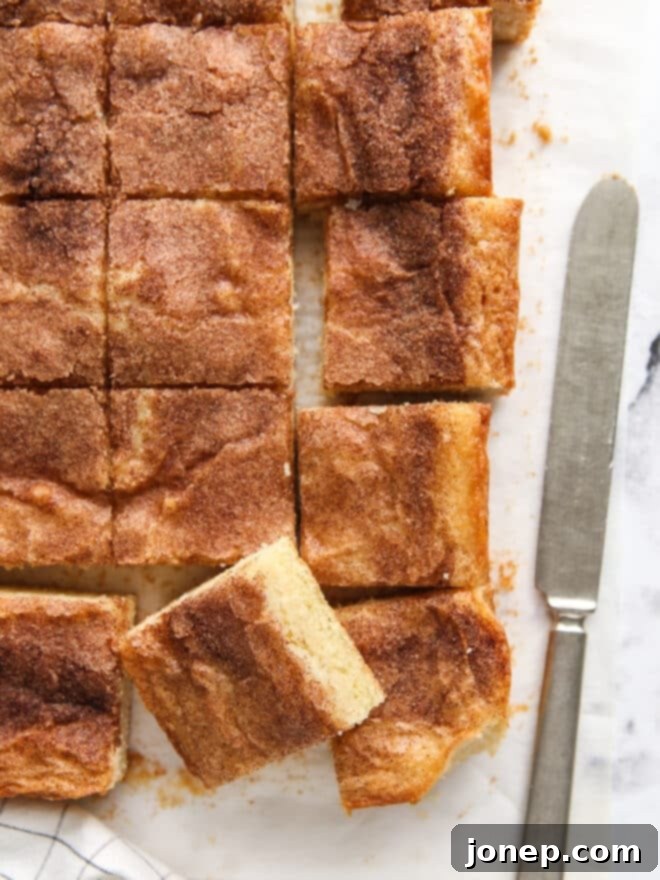 Decadent Cinnamon Gooey Butter Bars 3 sliced cinnamon gooey butter bars with knife