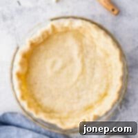 Master Blind Baking for Flawless Pie Crusts 12 Full blind baked pie crust with a rustic linen background, showcasing its perfect golden-brown color and intact edges.