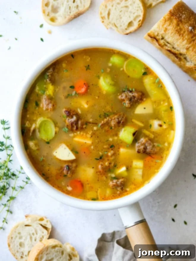 Rustic Italian Sausage & Leek Soup 3 A large pot of hearty potato leek and Italian sausage soup simmering on the stovetop, showcasing its rich texture and color.